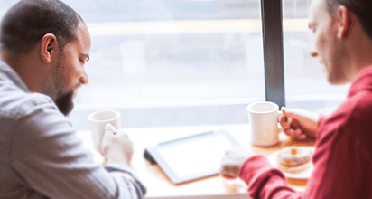 Image of two people looking iPad together